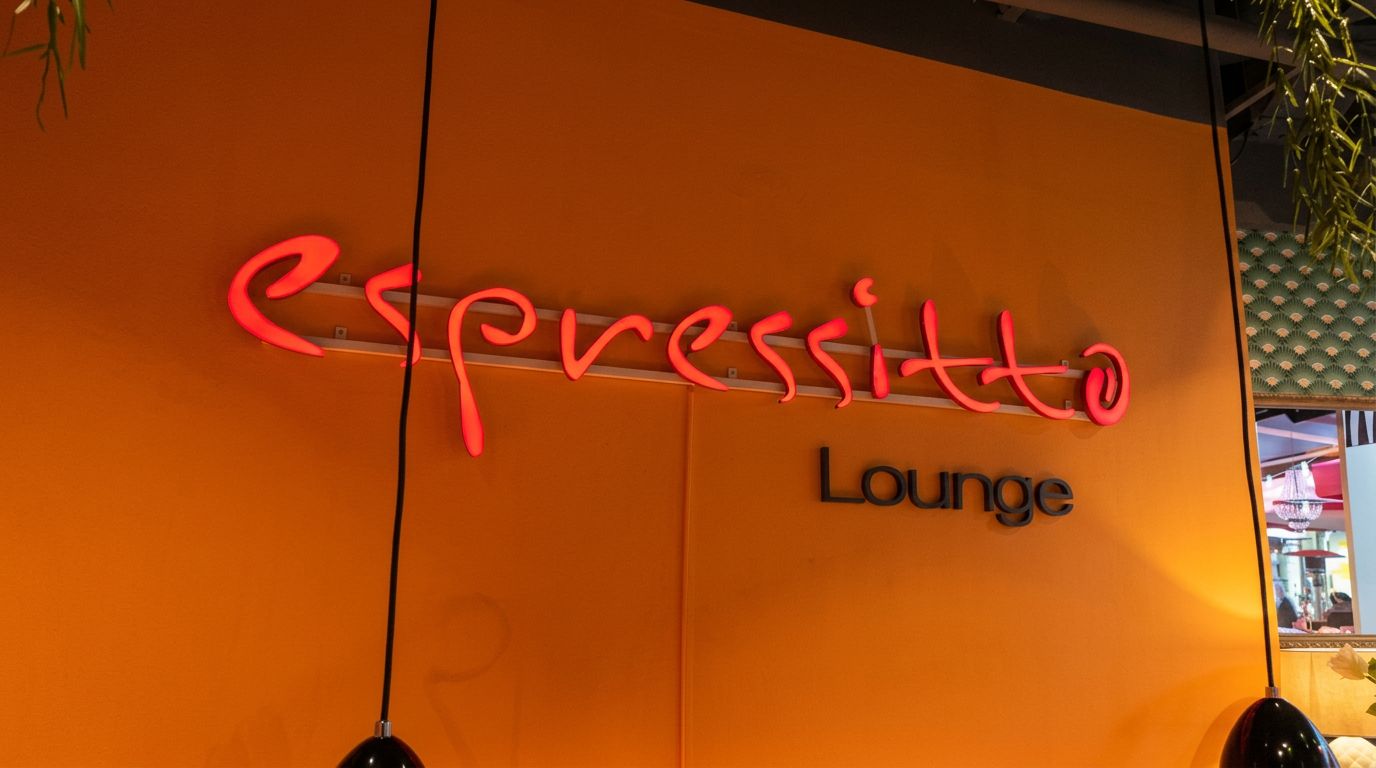 Espressitto Lounge Schriftzug im warmen Licht